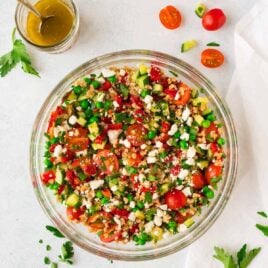Italian Farro Salad with feta, fresh tomatoes, veggies, and a bright red wine vinaigrette. Delicious, filling vegetarian recipe that’s perfect for healthy meal prep, light lunches, or a side dish with dinner. Tastes great leftover and at room temperature, so it’s a perfect potluck and barbecue side dish recipe too!