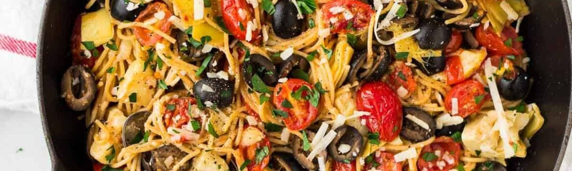 A skillet of Mediterranean pasta with olives and tomatoes