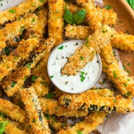 Baked zucchini fries with panko and Parmesan being dipped