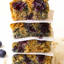 A stack of quinoa breakfast bars with blueberries