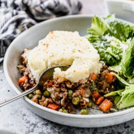 A serving of shepherd's pie on a plate with lettuce